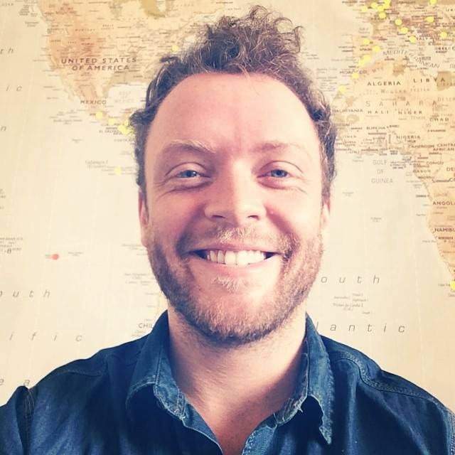 Photo of Gavin Morrice from the shoulders up, in front of an aged map of the world